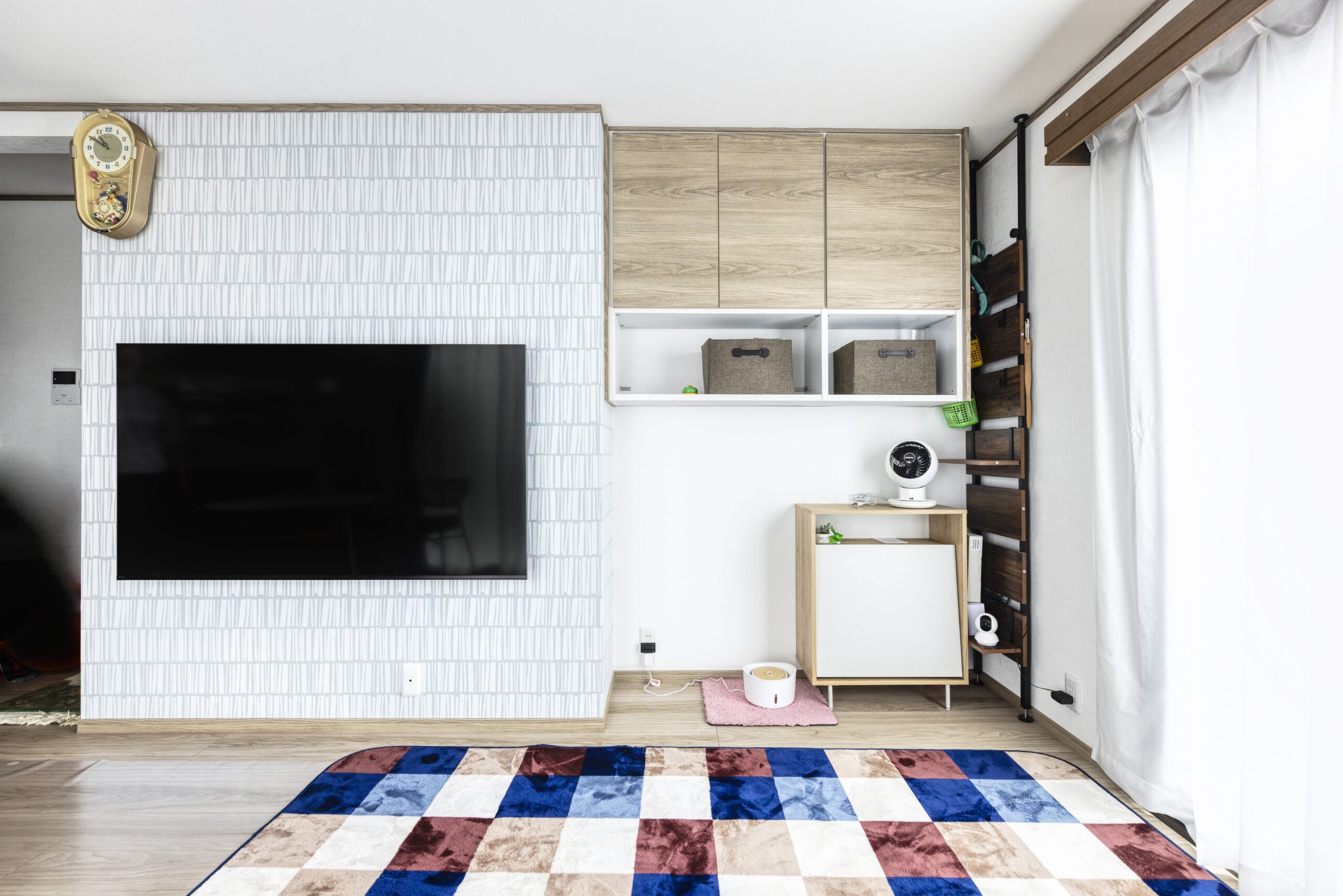 【リノベーションハイムの施工事例】壁掛けテレビと造作の吊り戸棚、足元にペット用スペースを設けた機能的なリビング壁面収納の施工事例